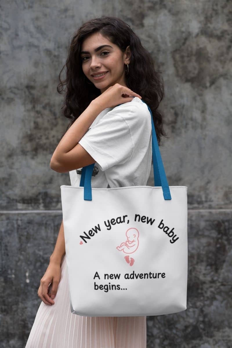 Baby announcement tote bag with a girl carrying a tote bag featuring the text 'New year, new baby. A new adventure begins...'