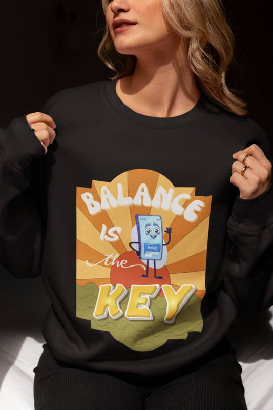 Balance Is The Key sweatshirt with a person wearing a black sweatshirt with a graphic design and text 'Balance is the Key' on a dark background