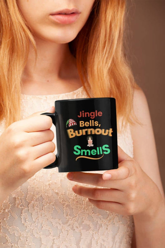 Burnout becovery coffee mug with a person holding a mug with humorous text 'Jingle Bells, Burnout Smells'