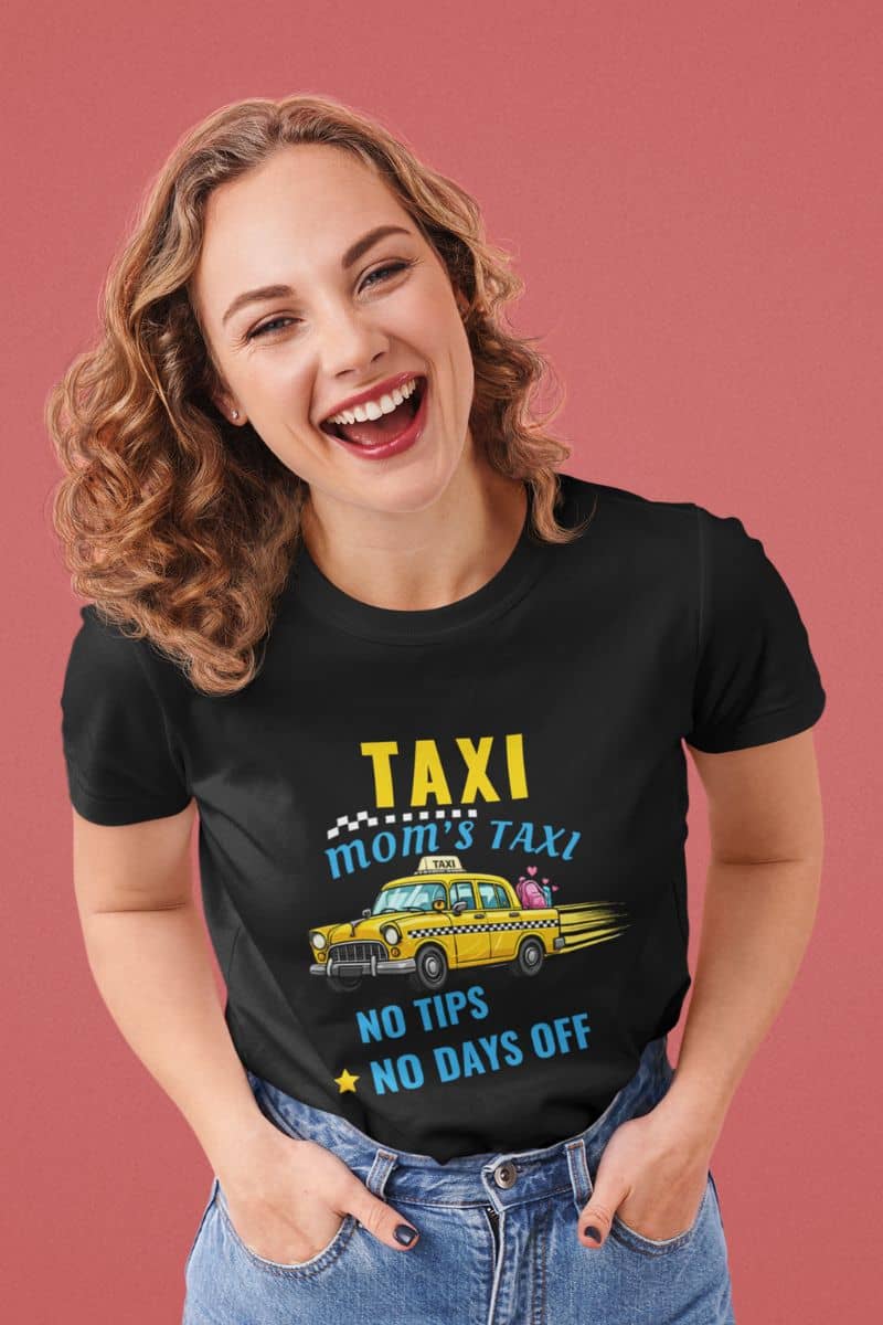 Busy mom shirt with a woman wearing a black t-shirt with a taxi graphic and text 'Taxi, Mom’s Taxi – No tips, no days off' on a pink background