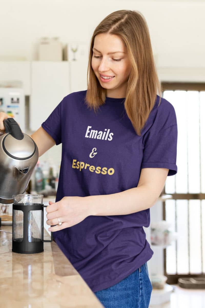 Caffeine addict shirt with a woman in a kitchen wearing a purple t-shirt with 'Emails & Espresso' text.