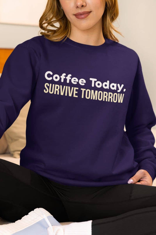Caffeine quote sweatshirt featuring a woman in a purple sweatshirt with the text 'Coffee Today, Survive Tomorrow' on the bed