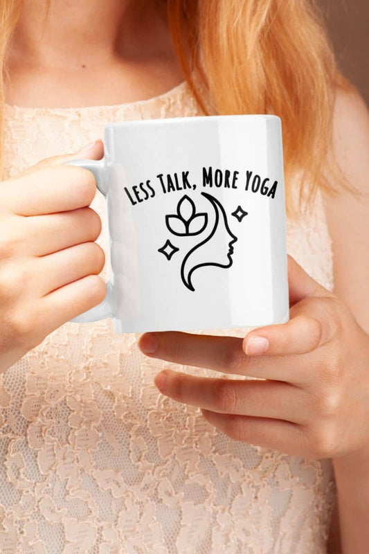 Calm morning coffee mug with a person holding a white mug with 'LESS TALK, MORE YOGA' text and a face design.