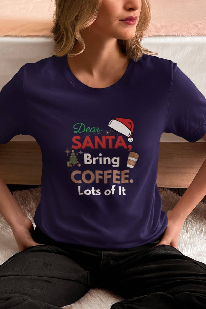 Christmas coffee lover shirt showing a woman wearing a purple t-shirt with the quote 'Dear Santa, Bring Coffee. Lots of It.'