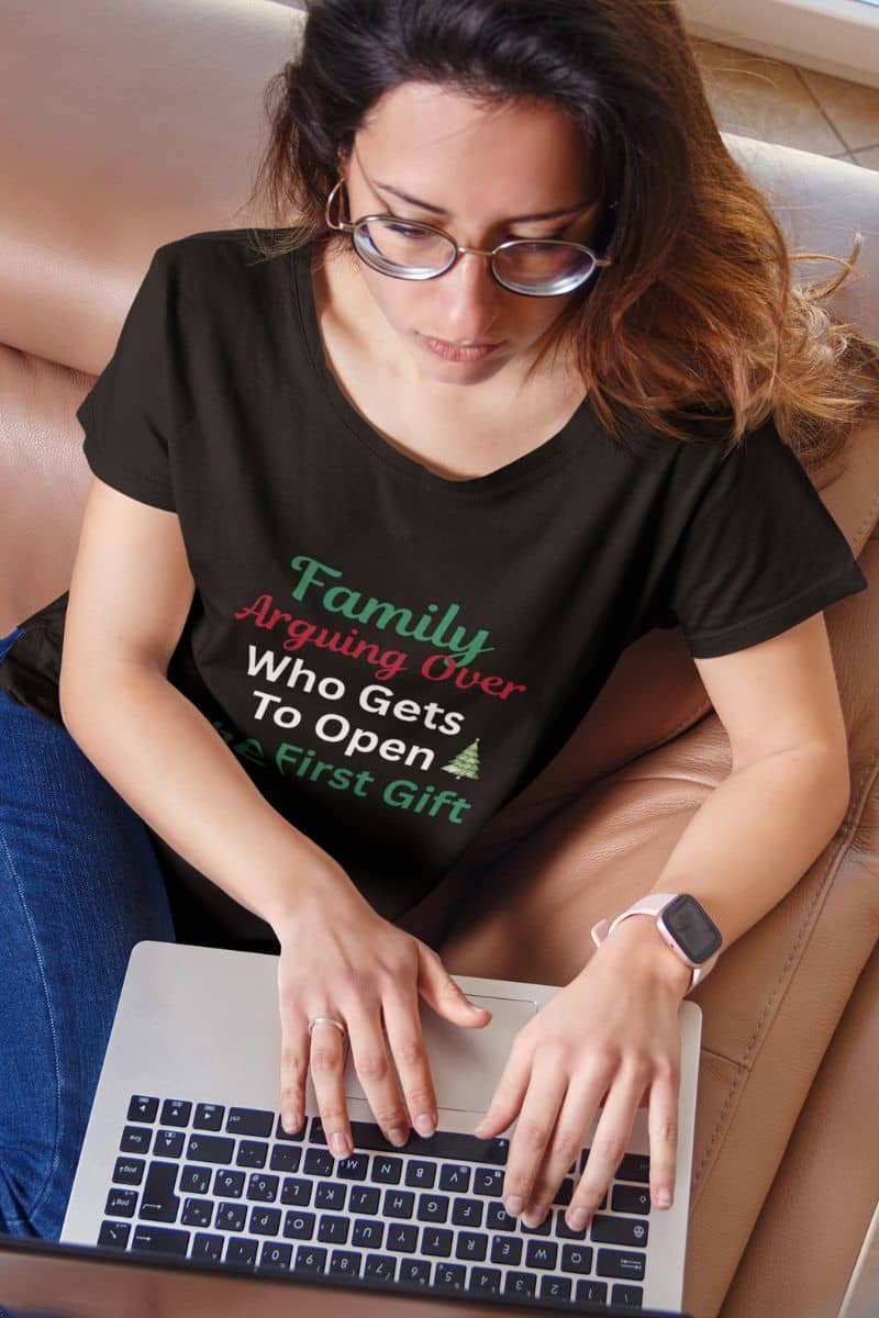 Christmas gift shirt for dad with a woman wearing a black t-shirt with humorous text while using a laptop.