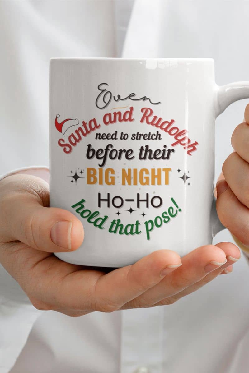 Christmas morning coffee mug with a person holding a ceramic mug with the quote 'Event Santa & Rudolph Need to Stretch Before their Big Night. Ho-Ho-Hold That Pose!'