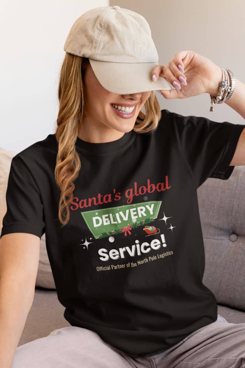 Christmas outfit idea with a person wearing a black t-shirt with 'Santa's global delivery service' text, sitting on a couch.