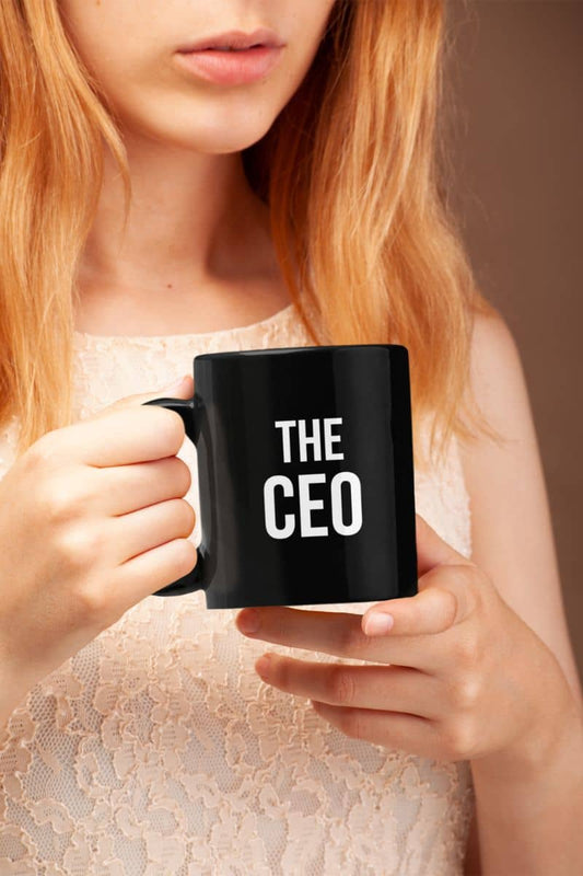 Coffee mug for men with a girl holding a black mug with 'THE CEO' text against a neutral background