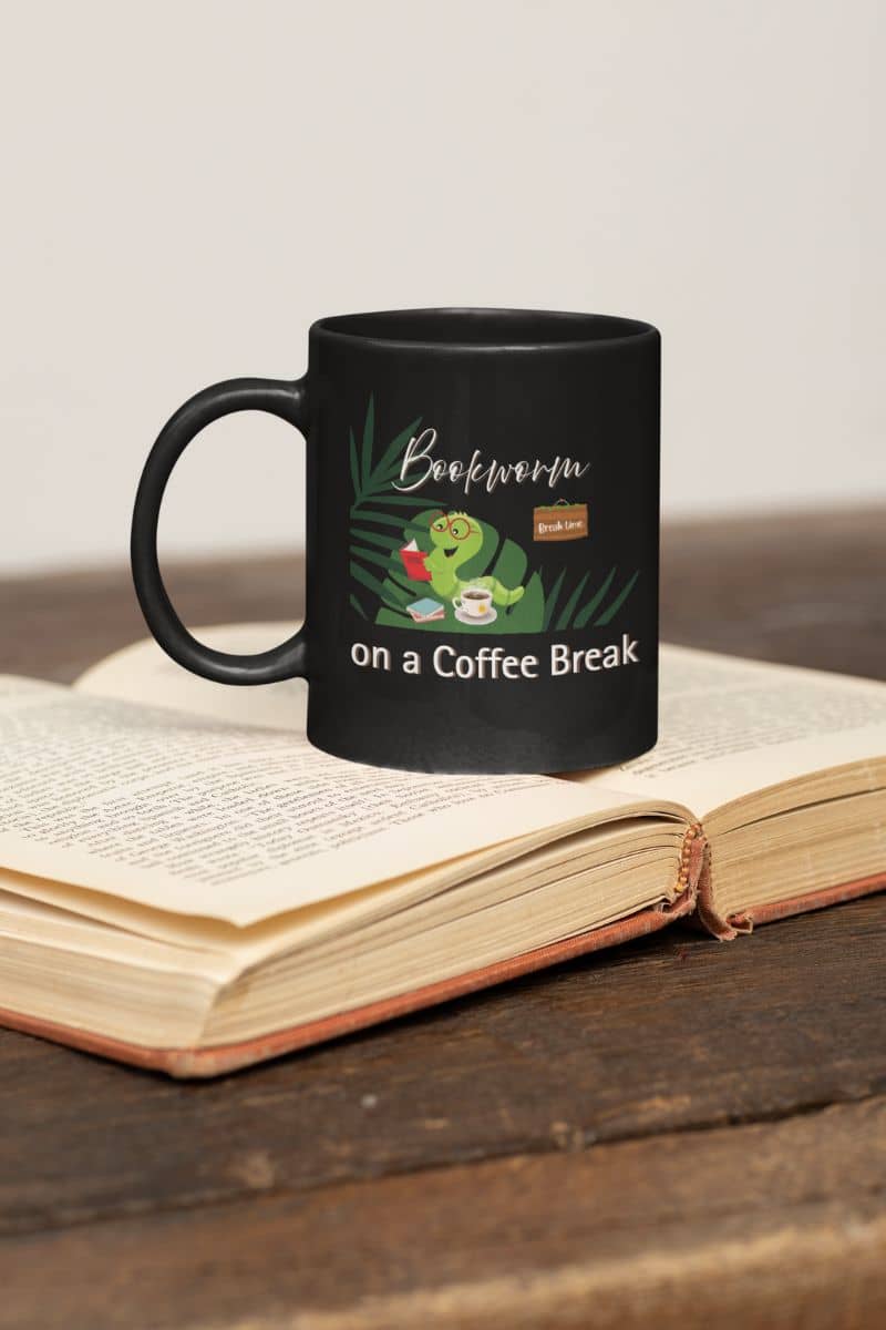 Coffee mug for readers with a black cup lying on an open book