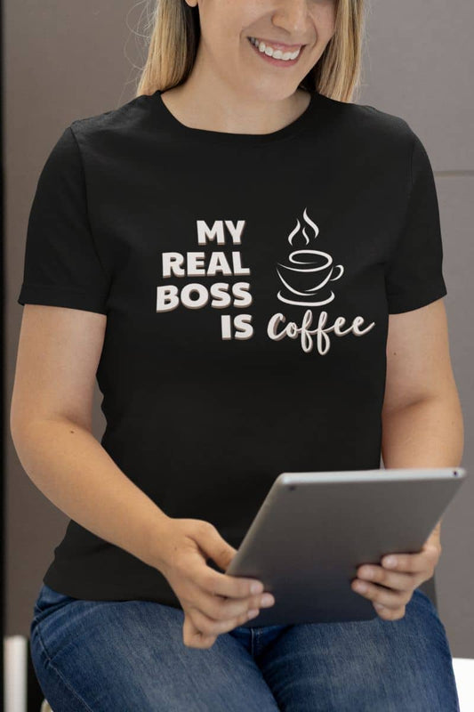 Coffee t-shirt with a person wearing a black t-shirt with 'My Real Boss is Coffee' text and holding a tablet.