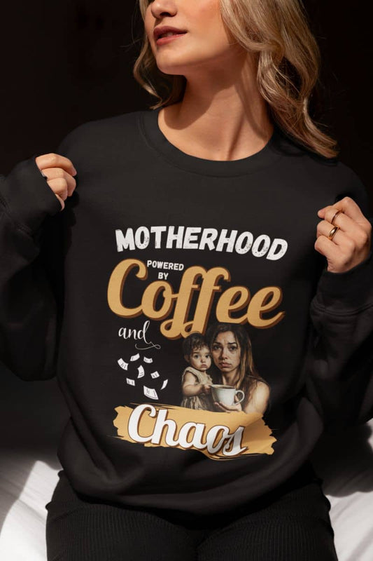 Comfy mom sweatshirt with a person wearing a black sweatshirt with text 'Motherhood powered by Coffee and Chaos' and a graphic of a woman and child.