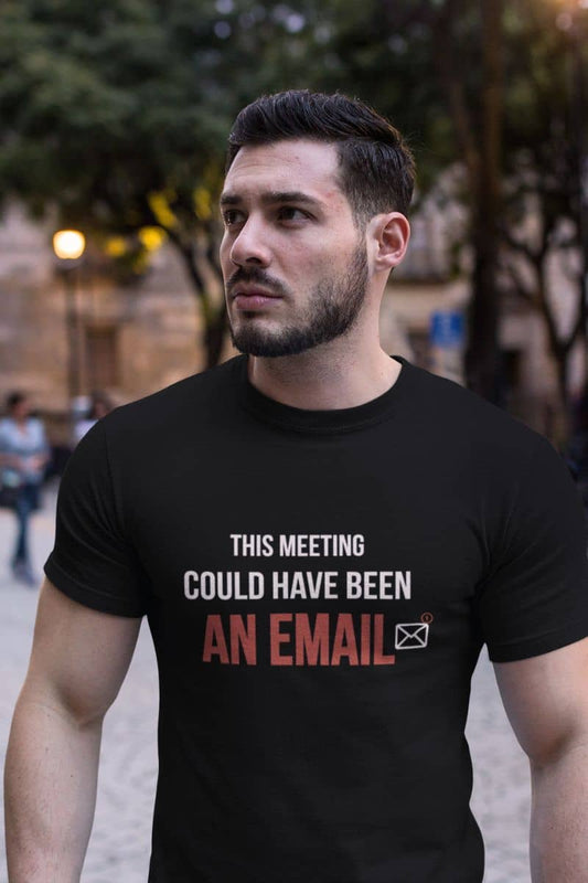 Corporate humor shirt with a man wearing a black t-shirt with text 'This Meeting Could Have Been An Email' in an urban setting 