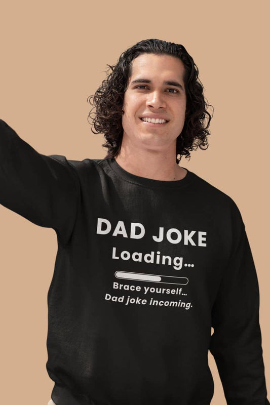 Dad joke sweatshirt with a man wearing a black sweatshirt with text 'Dad Joke Loading, Brace yourself…Dad joke incoming.' on a beige background