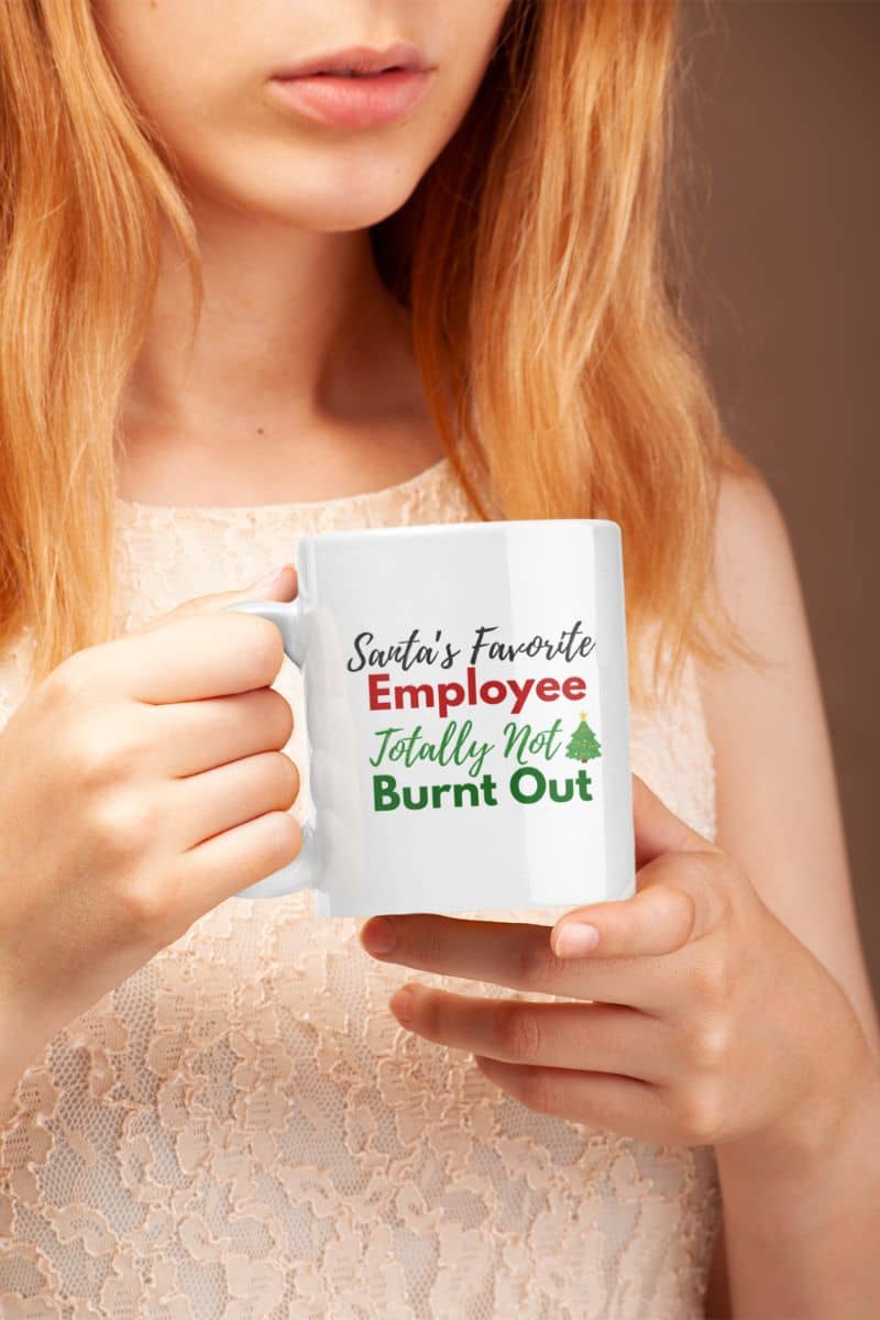 Daily grind sarcasm mug with a person holding a mug with text 'Sveta's Favorite Employee Totally Not Burnt Out' against a plain background