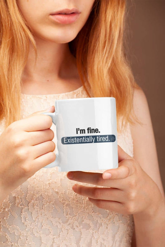 Existentially tired coffee mug with a person holding a mug with text 'I'm fine. Existentially tired.'