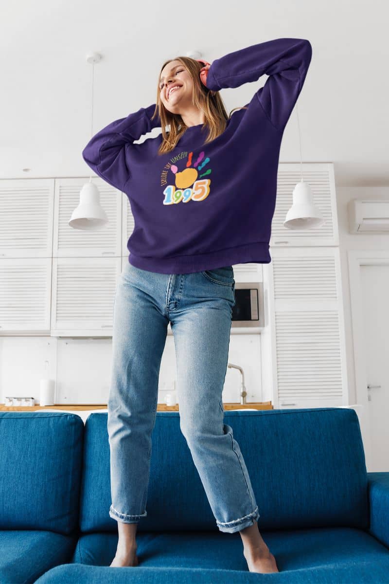 Explore the Unseen Sweatshirt with a girl listening to music and dancing on the sofa