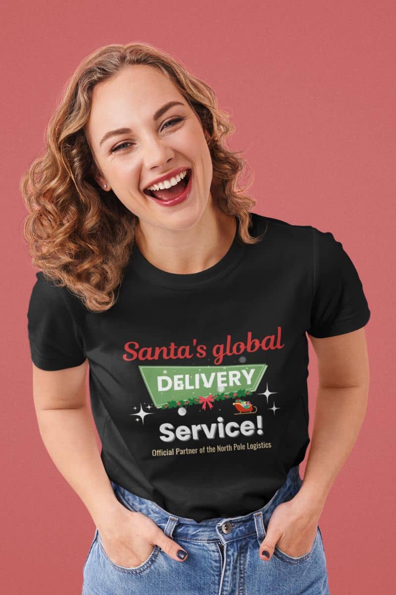 Festive holiday t-shirt with a woman wearing a black t-shirt with 'Santa's global delivery service' text on a pink background