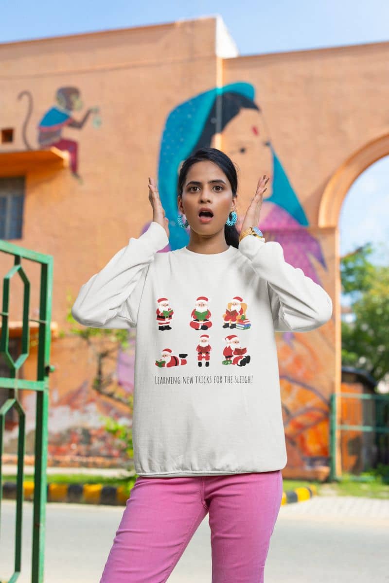 Learning New Stricks For The Sleigh - Fun Christmas Sweatshirt with a girl posing in front of the park