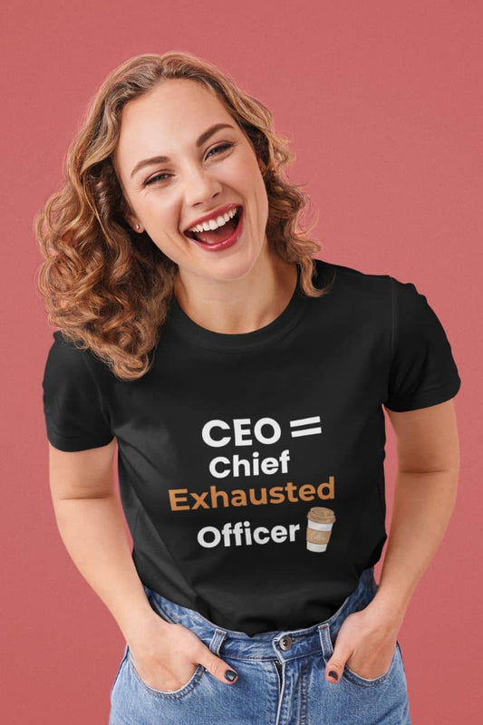 Funny CEO t-shirt with a woman wearing a black t-shirt with a humorous office quote 'CEO = Chief Exhausted Officer' on a pink background