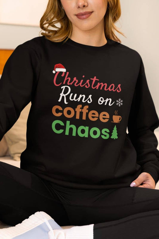 Funny Christmas coffee sweatshirt with a person wearing a black sweatshirt with text 'Christmas Runs on Coffee & Chaos'