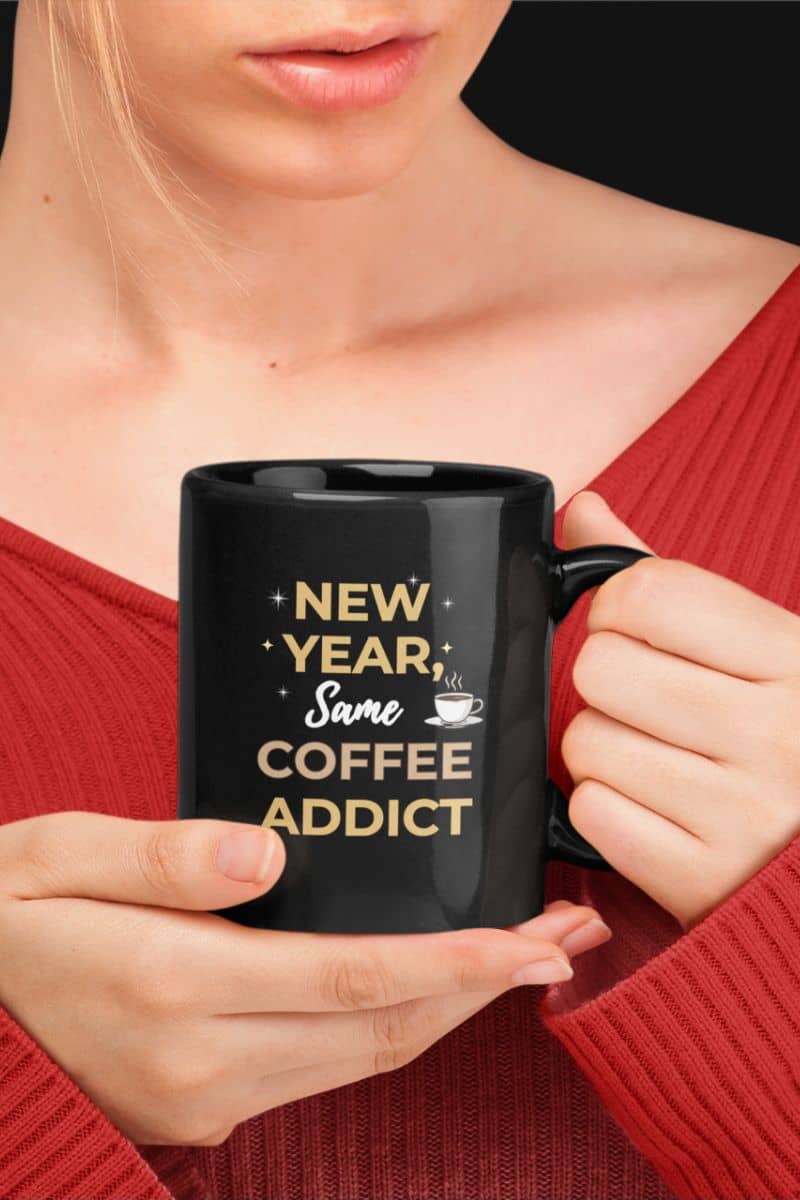 Funny coffee mug for work with a person holding a black mug featuring the text 'New Year, Same Coffee Addict'