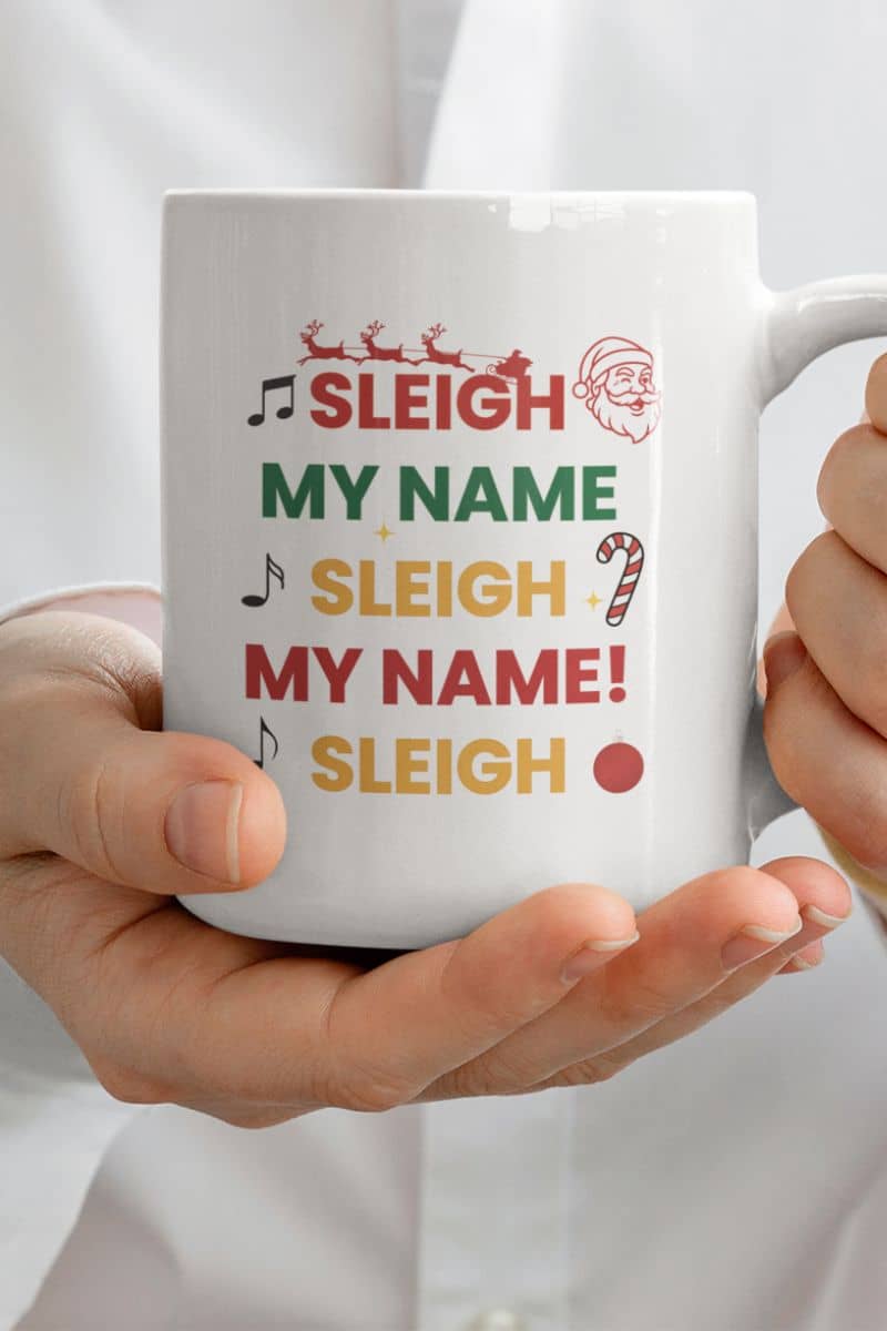 Funny Santa Sleigh mug with a white mug with text 'Sleigh My Name, Sleigh My Name' held by hands against a white background