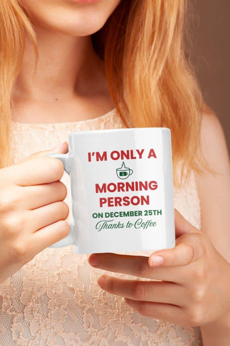 Funny christmas coffee mug with a person holding a mug that reads 'I’m Only a Morning Person on December 25th'