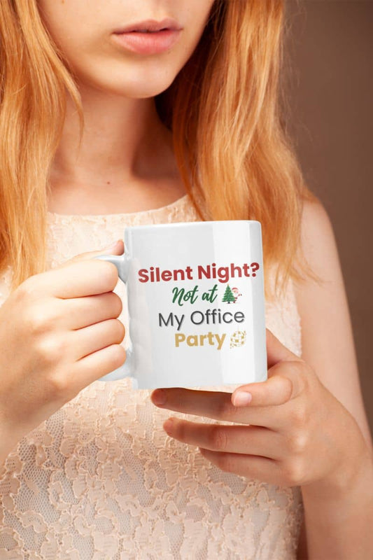Funny coworker Christmas mug with a person holding a mug with text 'Silent Night? Not at My Office Party' against a neutral background
