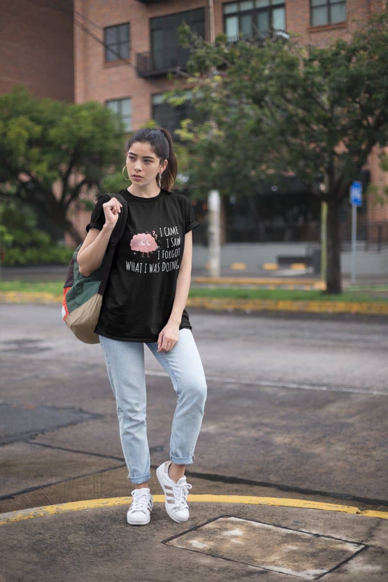 Funny graphic t-shirt with a girl carrying a backpack standing and posing in the school yard