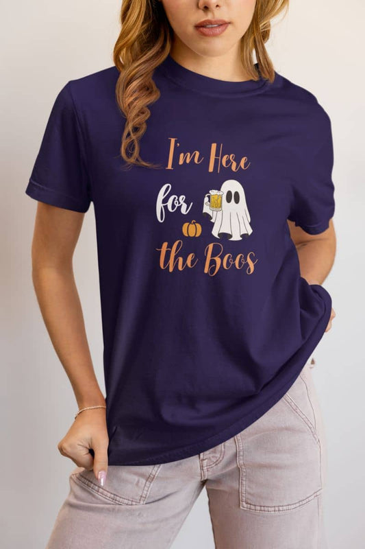 Funny Halloween shirt showing a girl in a purple T-shirt with the text “I’m Here for the Boos.”