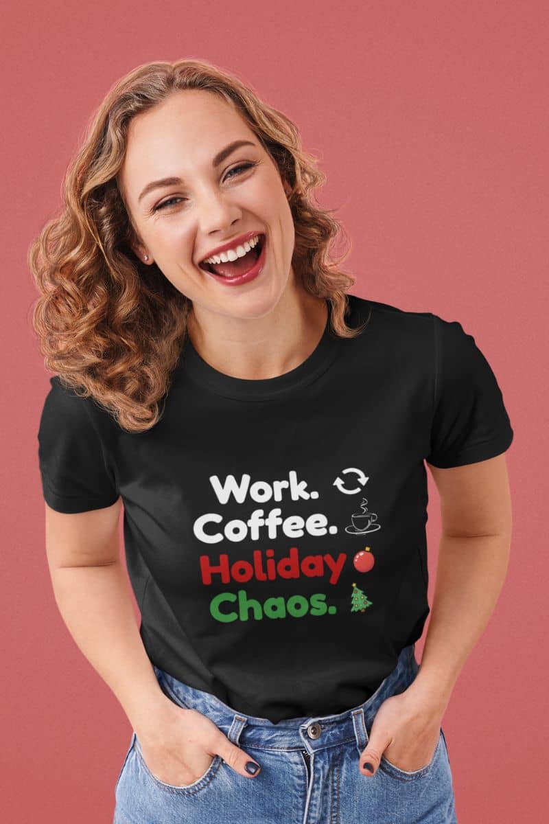 Funny holiday work shirt with a woman wearing a black t-shirt with text 'Work. Coffee. Holiday Chaos.' on a pink background