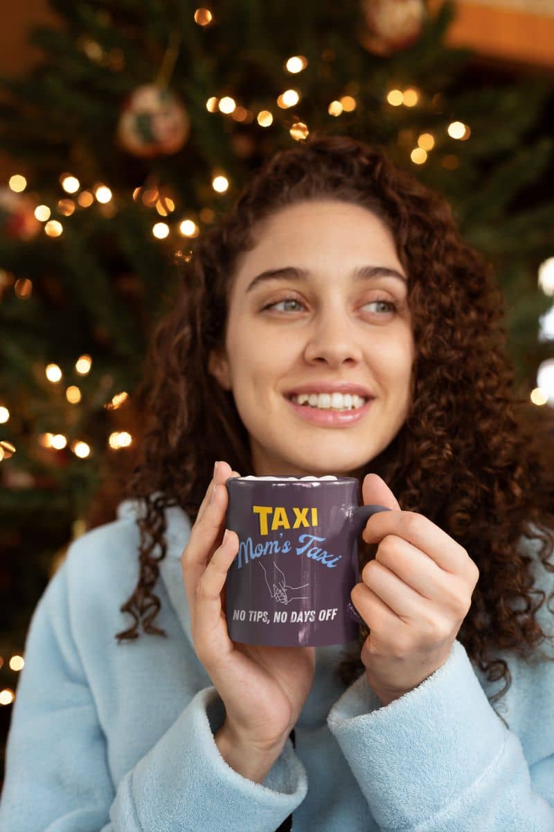 Funny mom's taxi coffee mug with a beautiful girl holding a cup of coffee in front of a Christmas tree