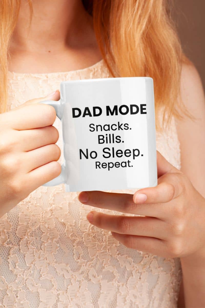 Funny mugs for dads with a person holding a mug with 'DAD MODE: Snacks. Bills. No Sleep. Repeat.' text