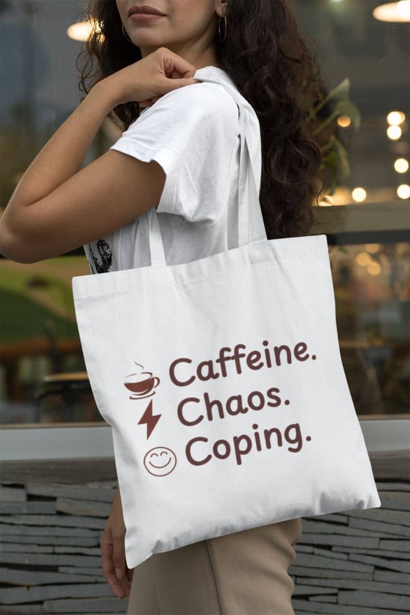 Funny productivity tote with a person holding a tote bag with 'Caffeine. Chaos. Coping.' text.
