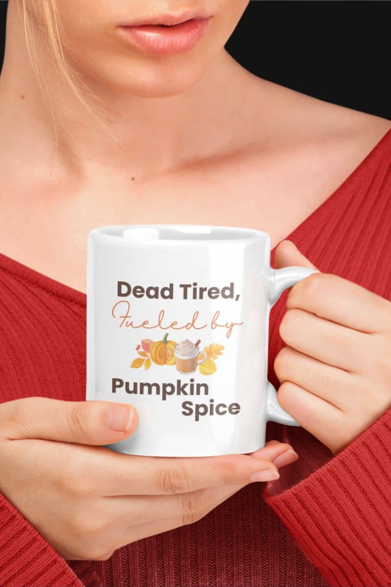 Funny pumpkin spice mug with a person holding a white mug with text 'Dead Tired, Fueled by Pumpkin Spice'