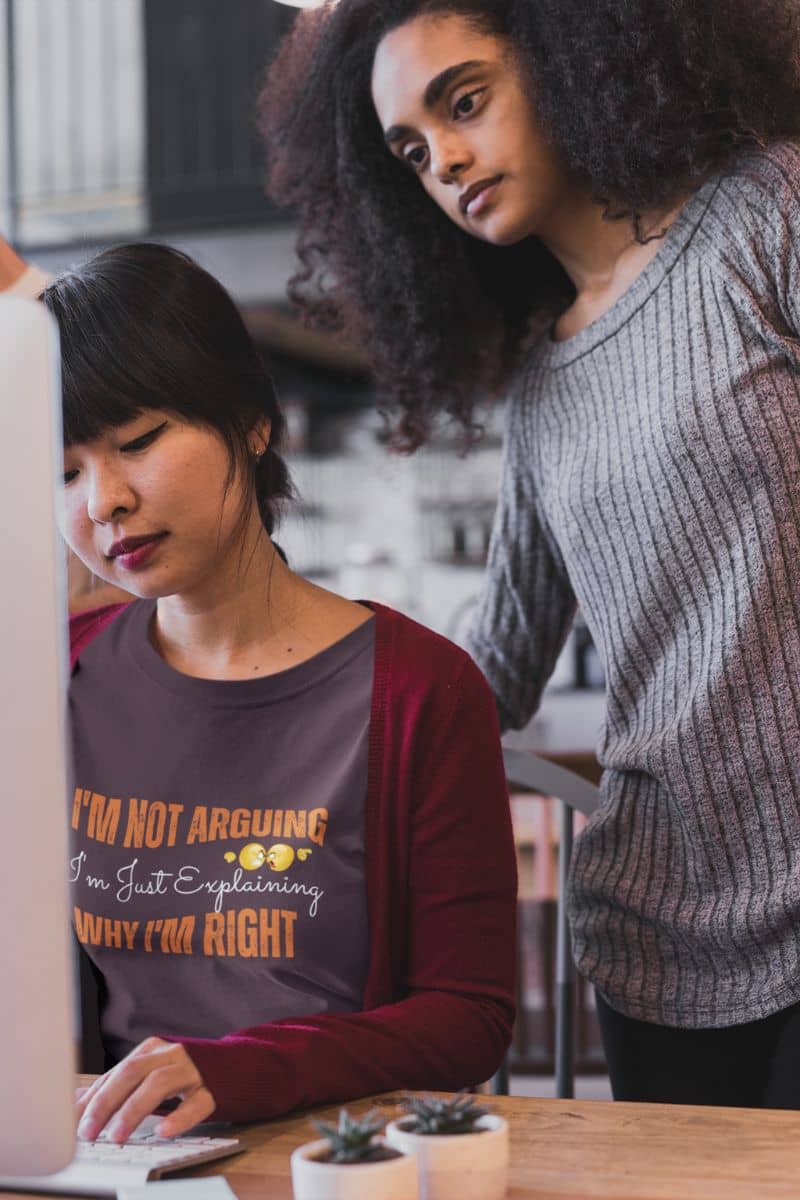 Funny t-shirt for smart thinkers with a girl standing behind her female colleague while looking at the computer screen