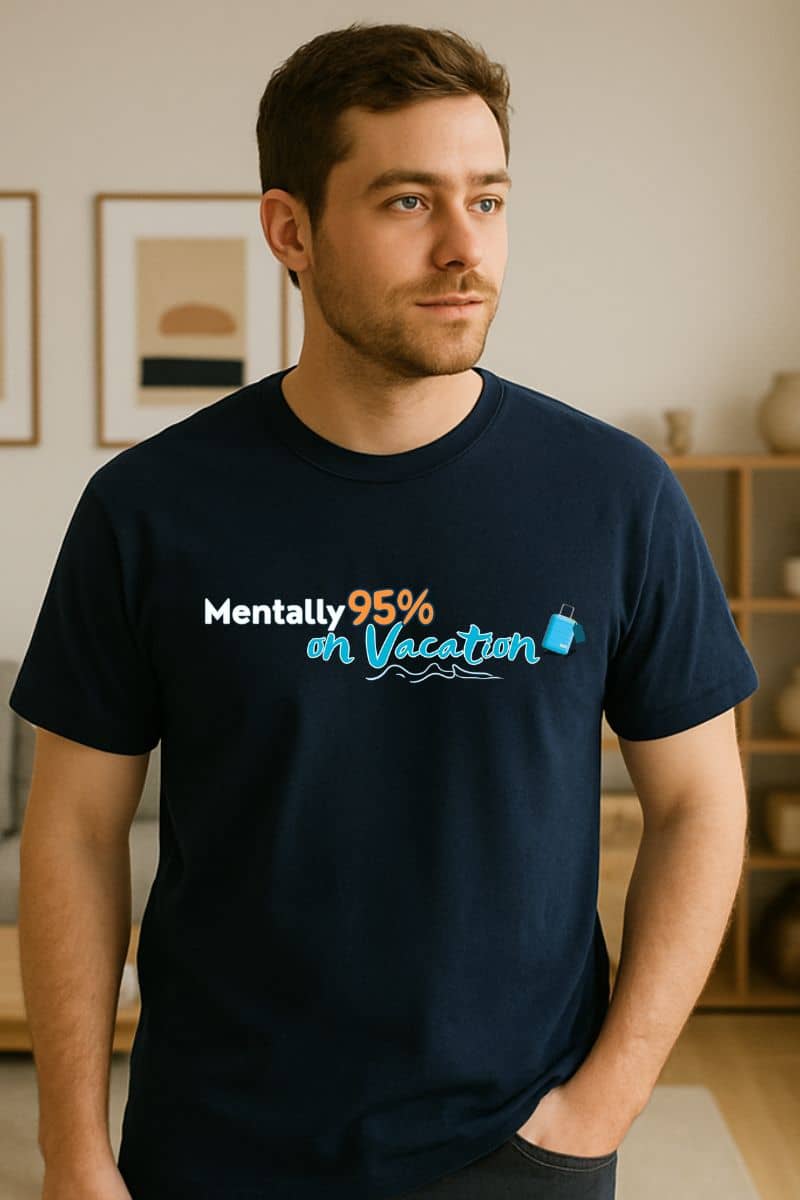 Funny vacation graphic tee a man wearing a navy shirt featuring the text 'Mentally 95% on Vacation' and graphics indoors