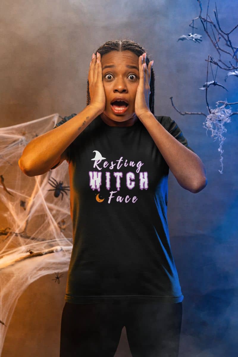 Funny witchy t-shirt with a person in a black t-shirt with 'Resting Witch Face' text in a Halloween-themed setting.