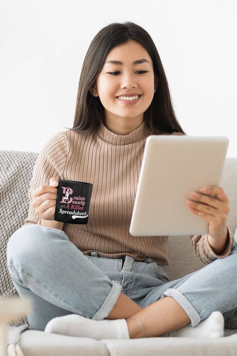 Funny work mug for women with a girl sitting on the sofa, watching an ipad and holding a cup in her hand