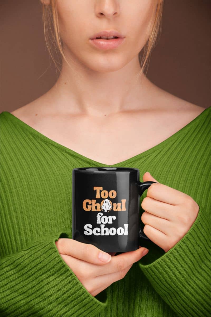 Halloween coffee mug with a girl holding a black mug with text 'Too Ghoul for School'