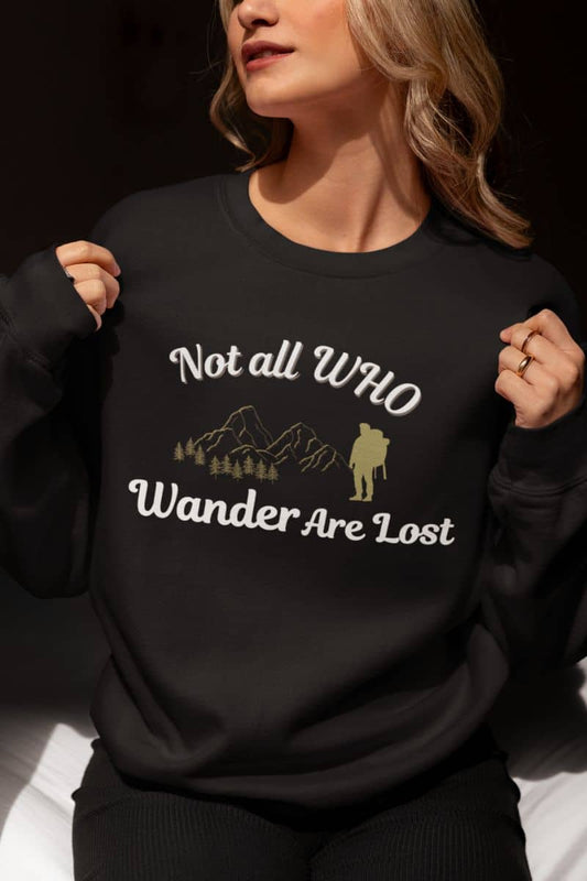 Hiking sweatshirt with a person wearing a black sweatshirt with a motivational quote 'Not all who wander are lost' and hiking graphic.