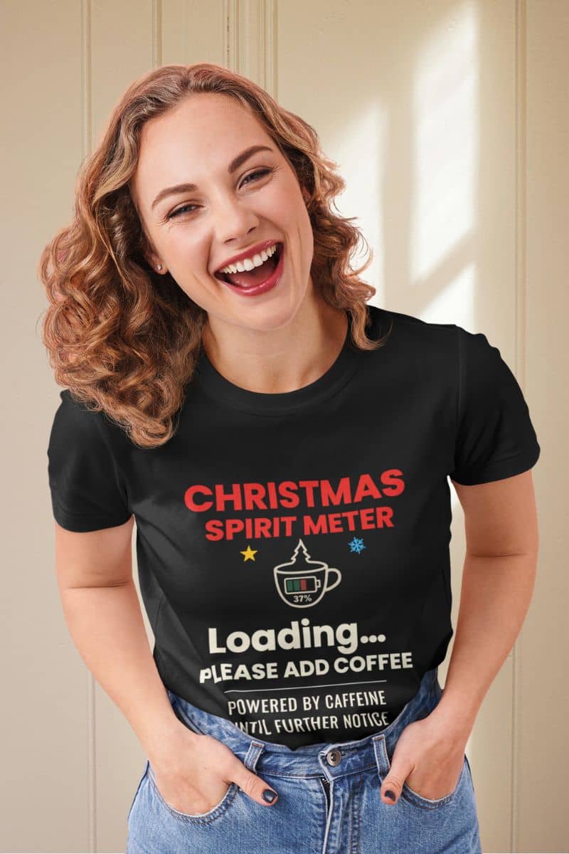 Holiday coffee lover shirt with a woman wearing a black t-shirt with text 'Christmas Spirit Meter, Loading…37%. Please add coffee. Powered by caffeine until further notice'