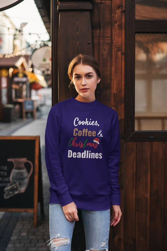 Holiday deadline sweatshirt with a woman wearing a purple sweatshirt with text 'Cookies, Coffee & Christmas Deadlines' standing in front of a wooden door.
