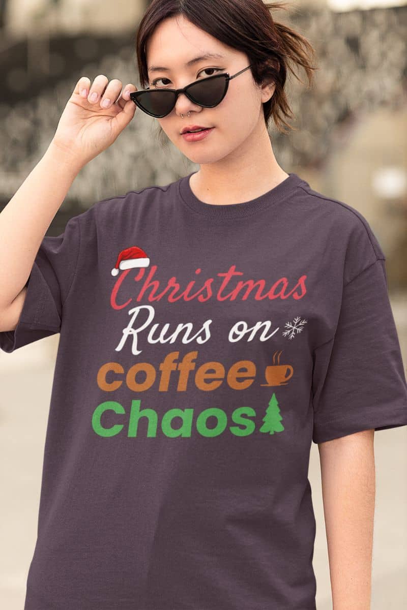 Holiday graphic tee with a person wearing a t-shirt with 'Christmas Runs on Coffee Chaos' text.