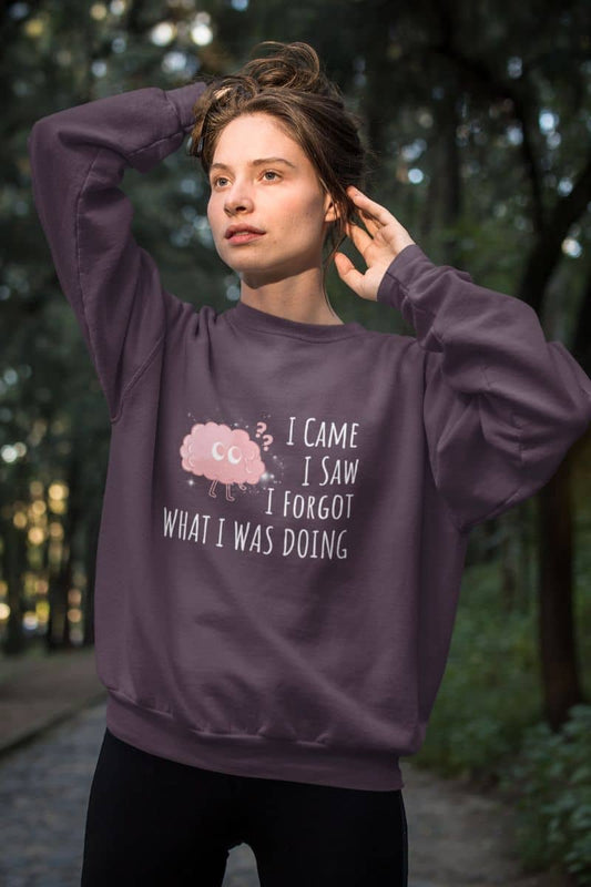 Humorous sweatshirt with a girl pulling her hair up to pose in the woods