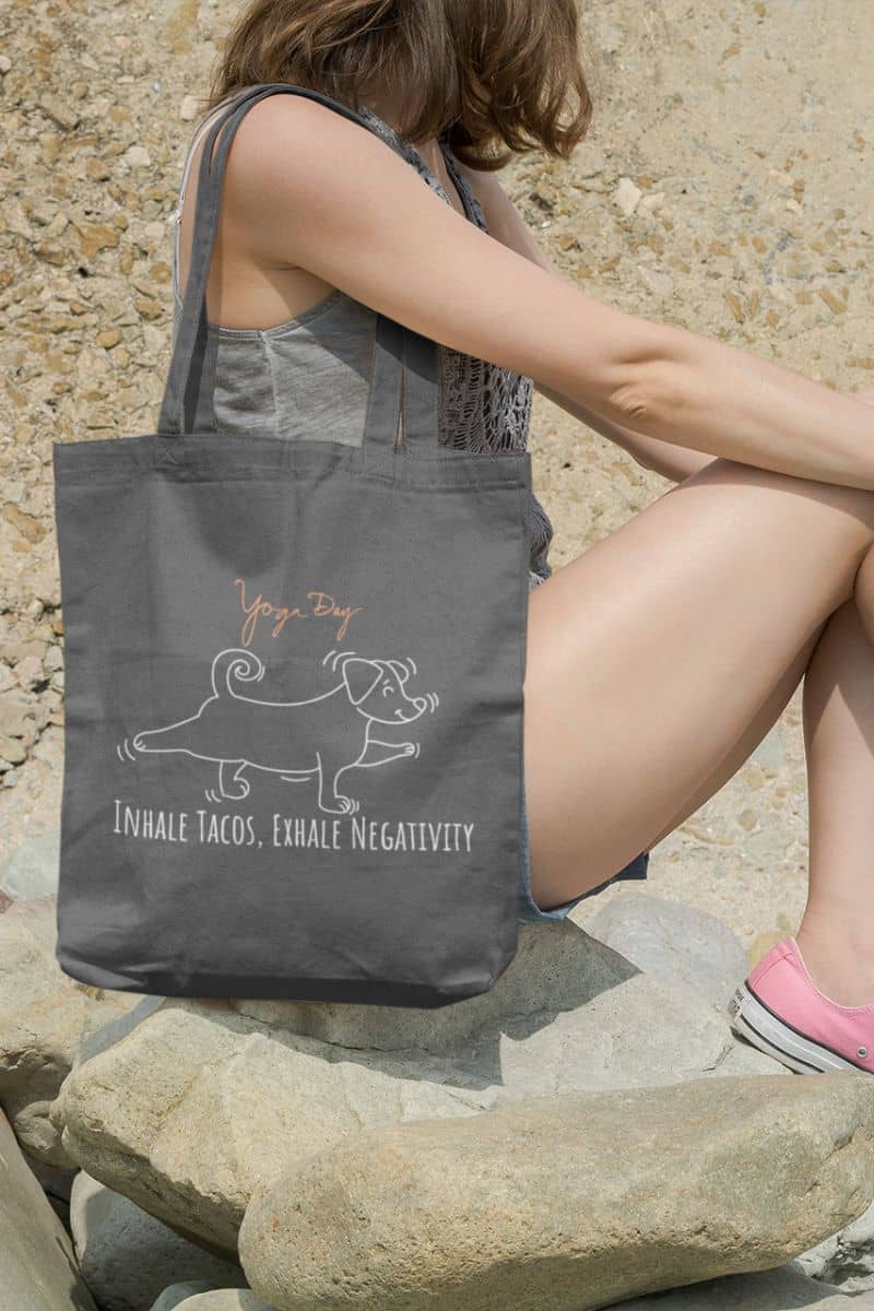 Inhale Tacos Exhale Negativity Tote Bag with a girl sitting on a rock