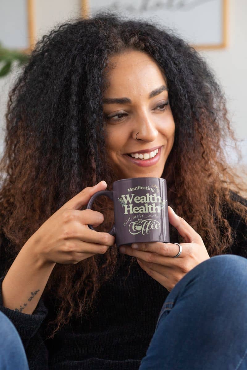 Inspirational coffee mug with a girl smiling and looking in one direction while holding a cup of coffee in both hands