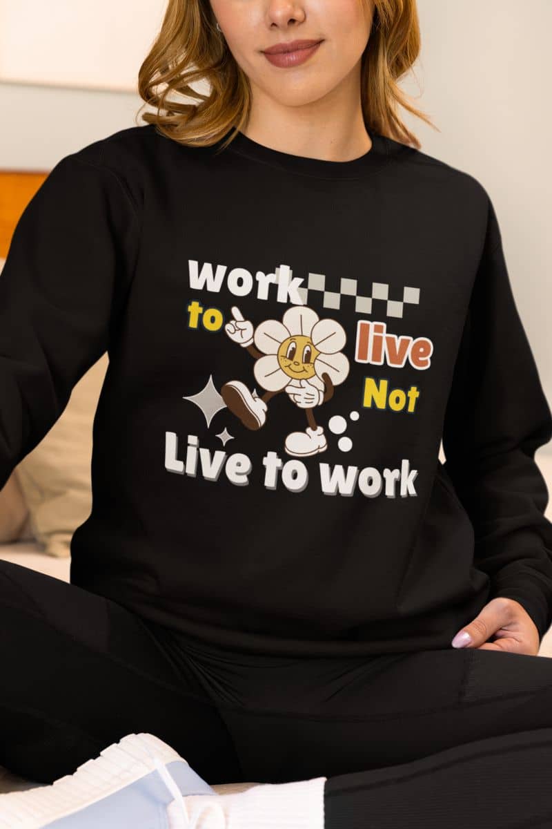 Inspirational sweatshirt with a person wearing a black sweatshirt with quote 'Work to Live, Not Live to Work' and cartoon character.