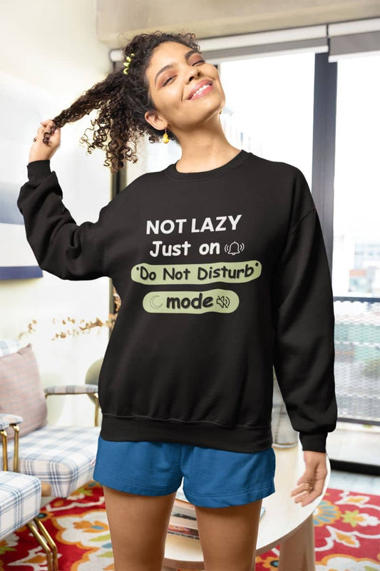 Introvert do not disturb sweatshirt with a woman wearing a black sweatshirt with humorous text 'NOT LAZY, Just on 'Do Not Disturb' mode' in a casual indoor setting