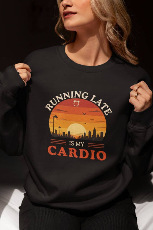 Lazy day sweatshirt with a person wearing a black sweatshirt with a sunset design and text 'Running Late Is My Cardio'.